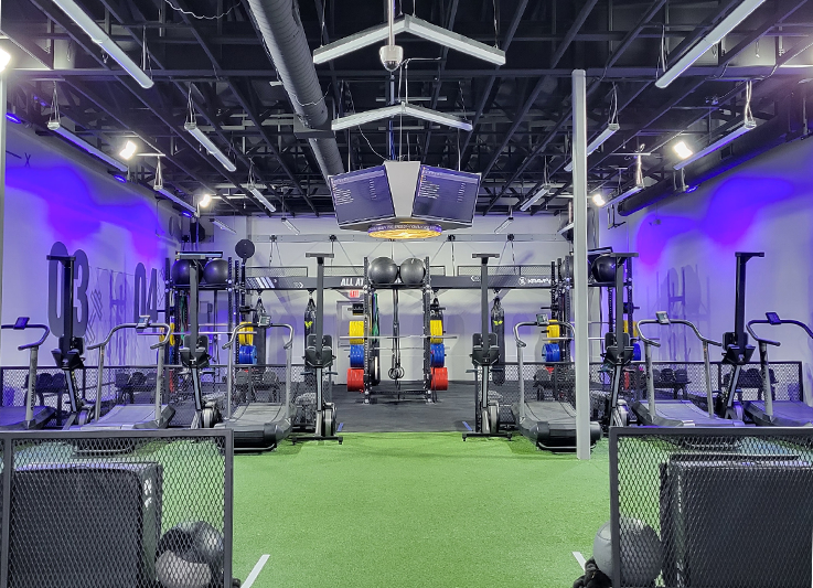 Training turf, strength equipment, and striking bags inside Krave Gym Waukee